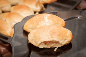 Delicious ruddy freshly baked pies laid out on a black plate