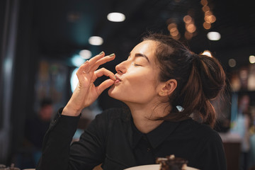 Closeup of woman eating chocolate cake in a cafe. selective focus, noise effect