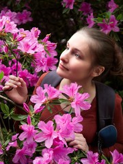 Portrait of a girl surrounded by pink rhododendron flowers.