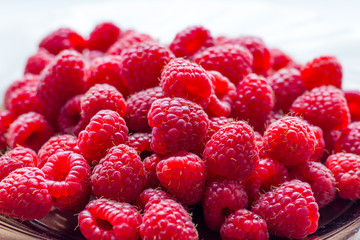 Red raspberries on a plate close-up, berries for consumption_