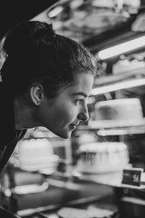 In pastry shop girl choose colorful cake and pie from showcase. selective focus, noise effect