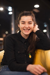 young attractive brunette is having fun at the cafe, smiling and posing for the photo in the evening. selective focus, noise effect