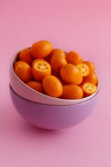 Kumquat fruits on a pink background