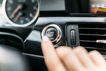 finger pressing the start button, stop the engine in the car. The driver is ready for the trip.