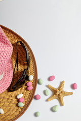 Accessories for summer holidays. Sun hats, sunglasses, colored pebbles and starfish on a white background.