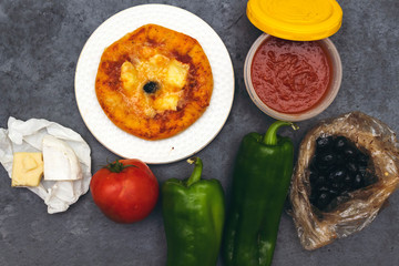 homemade arabic margarita mini pizza with  tomatoes, cheese, black olive, Thyme  ,green pepper and cheese on gray wooden background