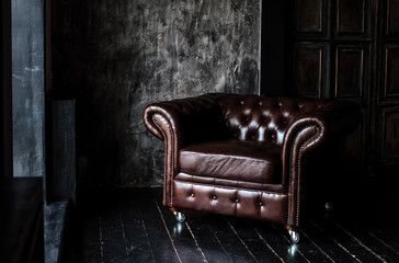 Sofa of brown leather standing in center