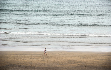 Fototapeta na wymiar Persona paseando sola por la playa
