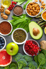 Healthy food background, spinach, quinoa, apple, blueberry, asparagus, turmeric, red currant, broccoli, mung bean, walnuts, grapefruit, ginger, avocado, almond, green peas and goji, top view
