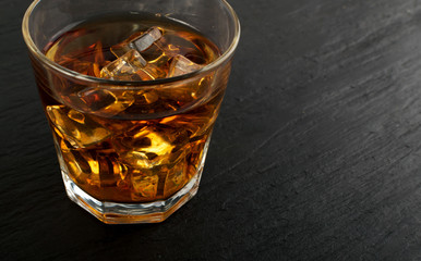 Iced Whiskey Glass on Natural Black Stone Background