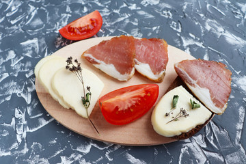 homemade cheese tomato and meat with spices on a wooden board