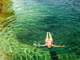 Woman floating in the clear water of a mountain river