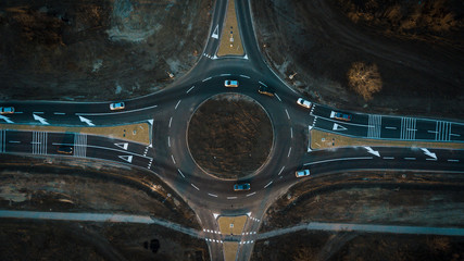 aerial view of cars are moving through a newly built traffic circle