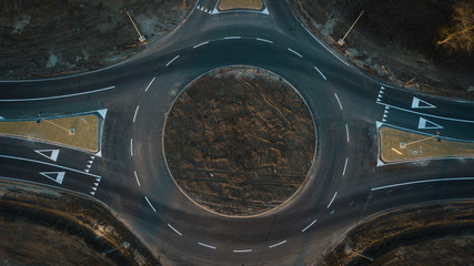 aerial view of cars are moving through a newly built traffic circle