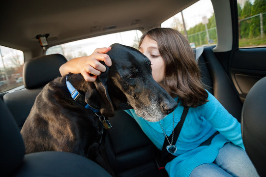 Girl gives her dog a kiss