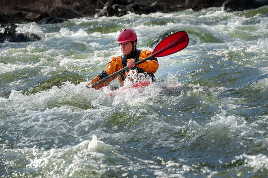 Man whitewater kayaks