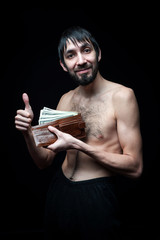 Young man with banknotes on black background
