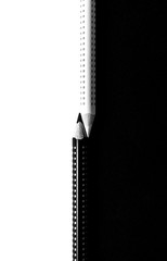 Two drawing pencils on a black and white surface.