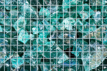 Turquoise broken pieces of glass behind the aluminium grille. Texture, background. - 252317036