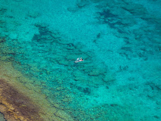 Fototapeta na wymiar Swimming alone in crystal clear blue sea