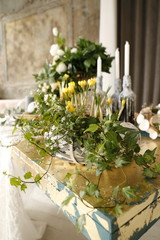Yellow crocuses in a basket, white roses and candles in the bottles in a spring Easter decor. Hello, March, April, May