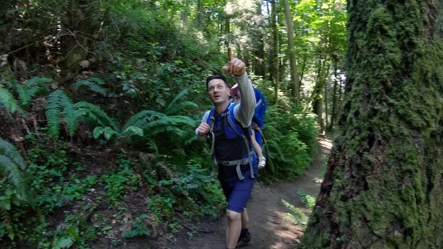 Dad Exploring Forest Trail with Baby Girl in Hiking Backpack