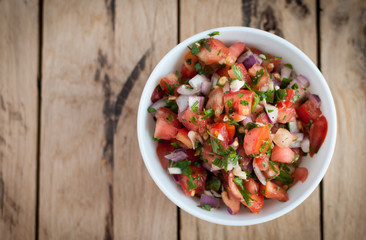 Spicy salsa dip on a wooden table, top view