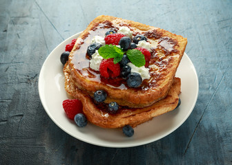 French cinnamon toast with blueberries, raspberries, maple syrup and coffee. morning breakfast