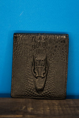 leather wallet with dragon on a wooden stand
