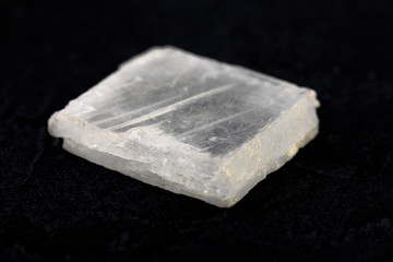 Natural mineral rock specimen - raw Gypsum stone from Gaurgak, Turkmenistan on black cement background.