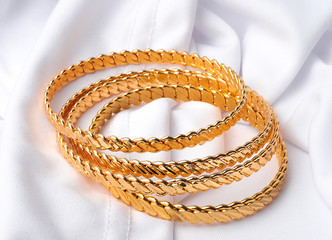 four golden bracelets on white background 