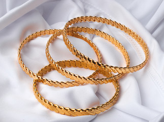 four golden bracelets on white background 