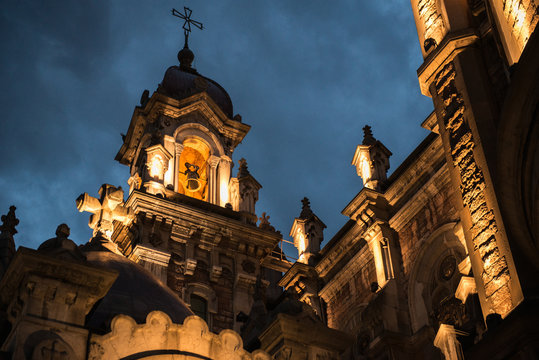From below of aged stone cathedral in lights under dark night sky, Spain