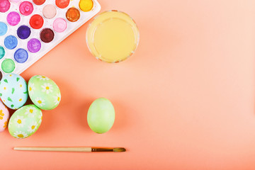 Hand painted Easter eggs, paints and brushes on a table. Preparation for the holiday.
