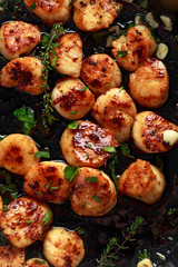 Scallops seared in garlic and parsley butter served in cast iron skillet