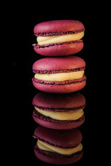 closeup tower of two purple macaroons with yellow filling