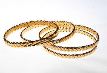 four golden bracelets on white background 