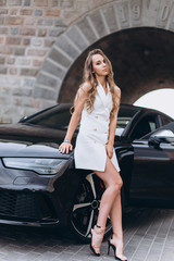 Luxury professional fashion model with new sport car outdoors. Fashion, transport, luxury concept