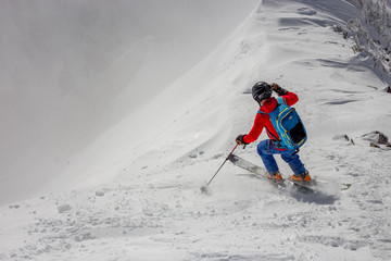 Male extreme skier dropping into slope