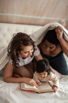 cheerful young family reading a novel , poems, book loves,close up photo