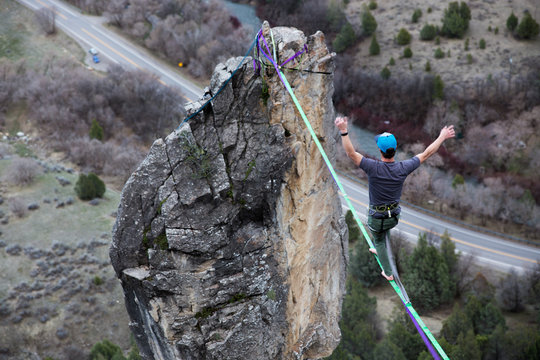 Male tightrope walker on highline over cliff