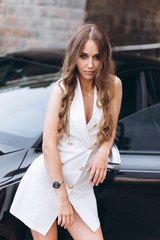 Luxury professional fashion model with new sport car outdoors. Fashion, transport, luxury concept