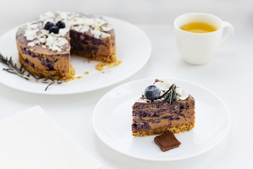 Blueberry - chocolate cheesecake on a white wooden table