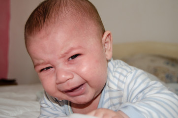 cute 4 months old baby boy got tired of tummy time and starting to cry