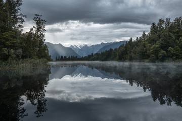 Fototapeta premium Distant snowy mountain is reflected in the Lake Matheson water