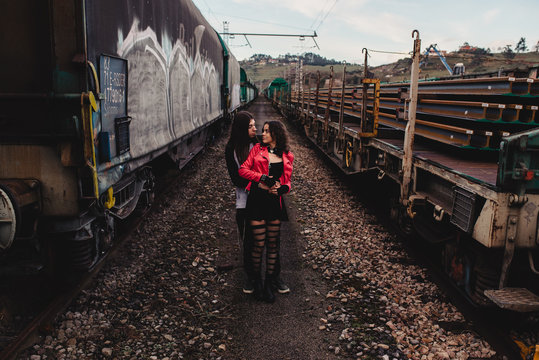 Long haired man hugging and kissing woman near train