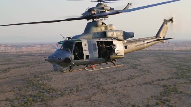 Huey helicopters fly in formation in this slow motion action battle scene.