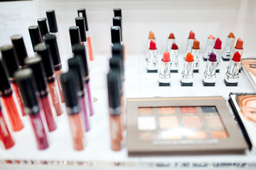 women's decorative cosmetics in the form of lip gloss, lipstick of different colors, as well as shadows in the palette