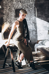 Fashionable portrait of young stylish hipster caucasain girl with haircut in black studio. Sexy, glamourous, gorgeous young woman