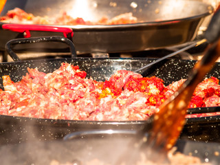 Unrecognizable person cooking traditional food called chichas on the street at a popular party in a village in Spain